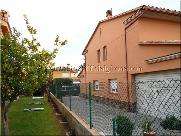 Montaje de seto artificial girona en una valla metálica entre vecinos.